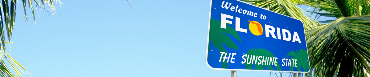 Welcome to Florida roadside sign against a bright blue sky