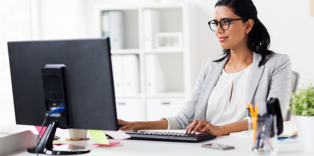 smiling woman looking at a computer monitor